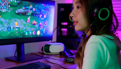 Chica utilizando un ordenador de sobremesa representando plataformas digitales y gaming online
